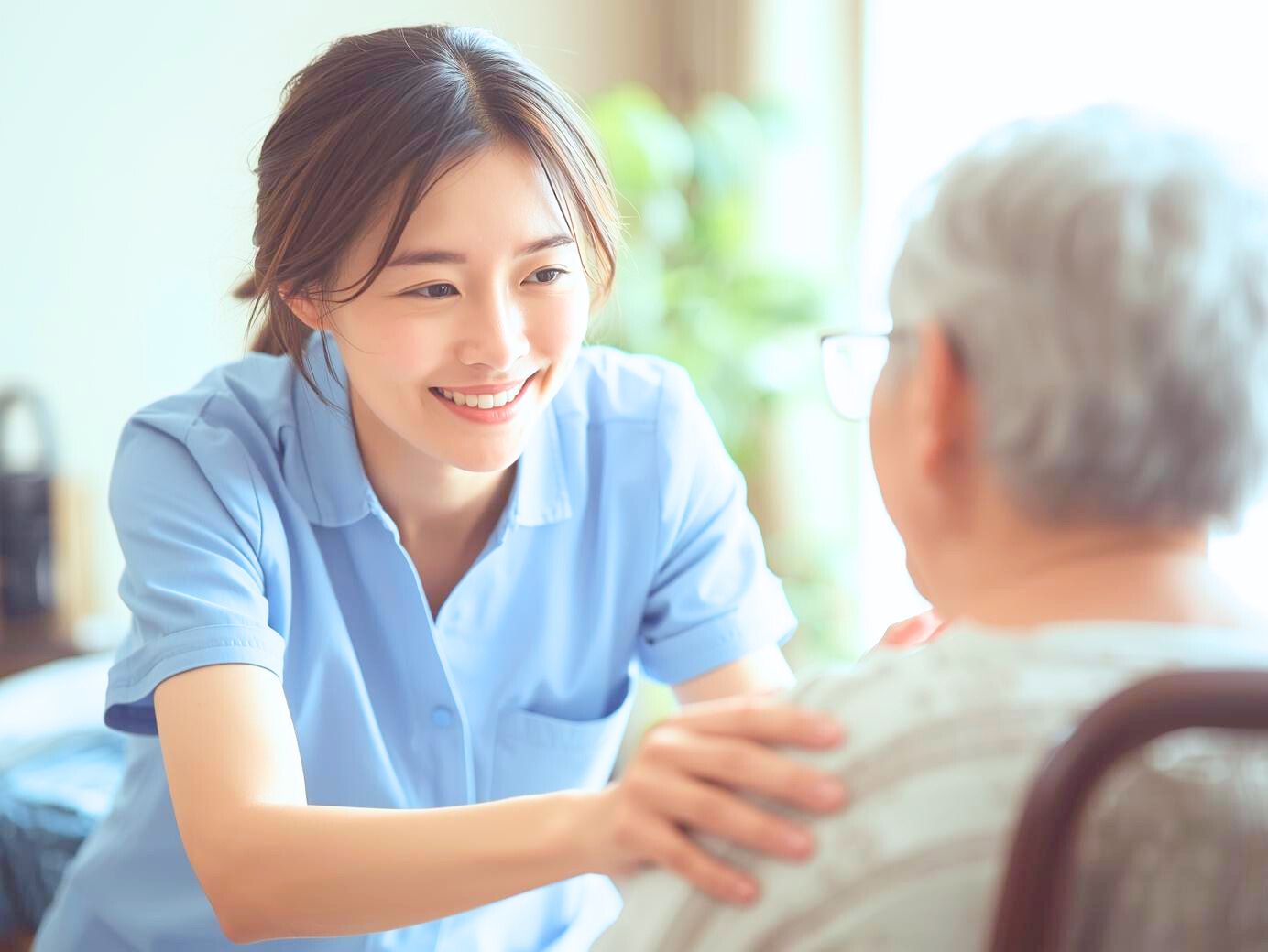 高齢者の手を取りながら笑顔で語りかける介護士