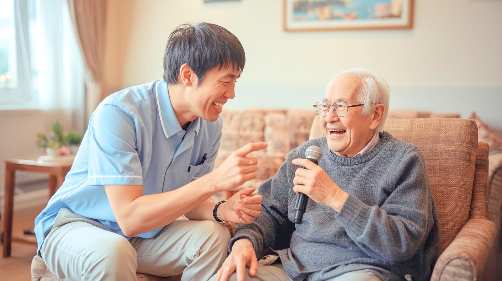 高齢男性にマイクを向け一緒にカラオケを楽しむ男性介護士